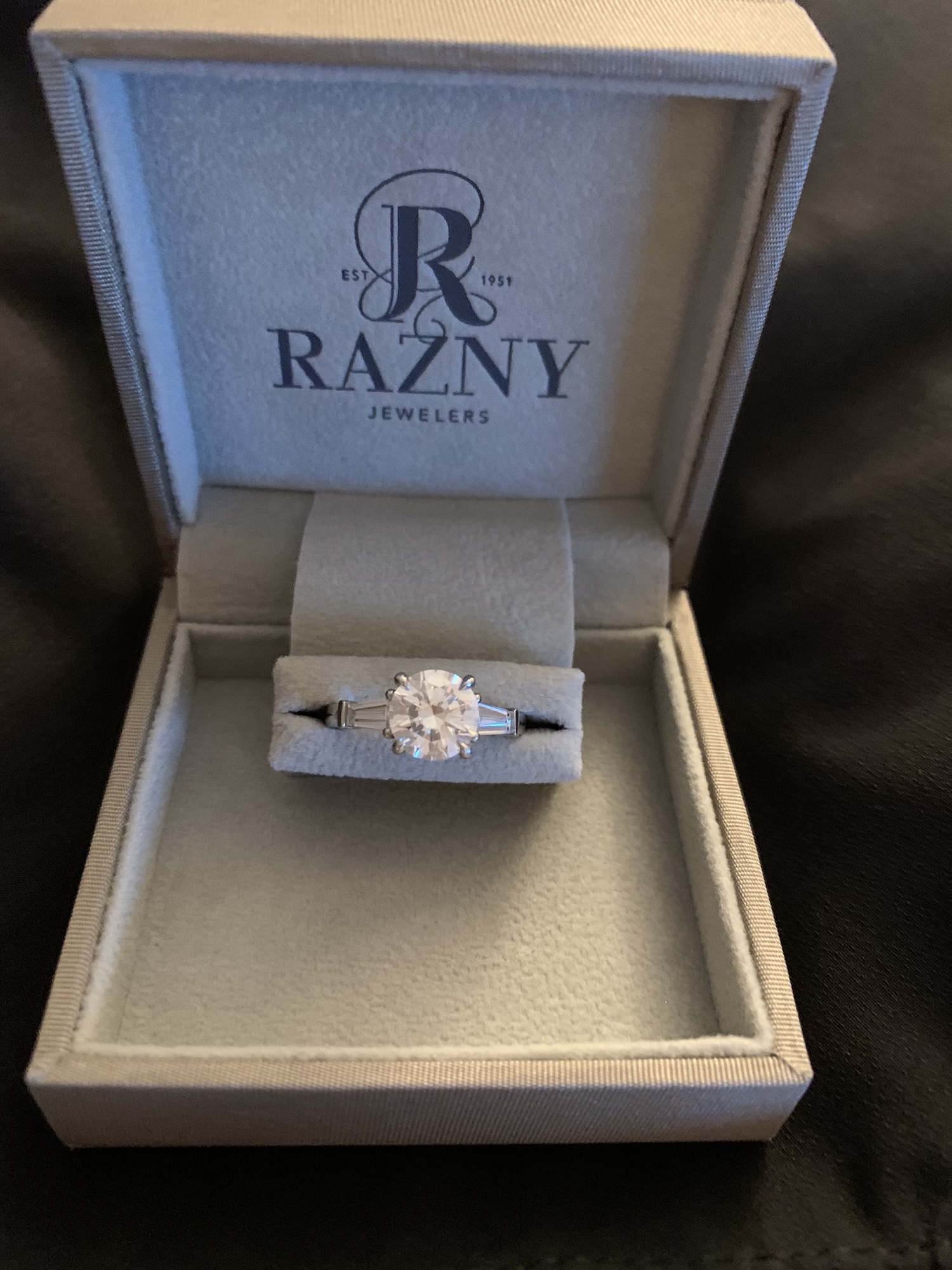 A box with a logo of a razny on it and a ring