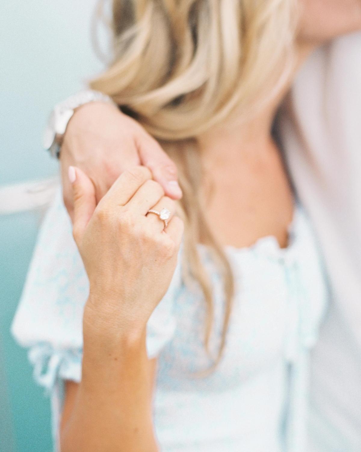 A couple holding her hands together