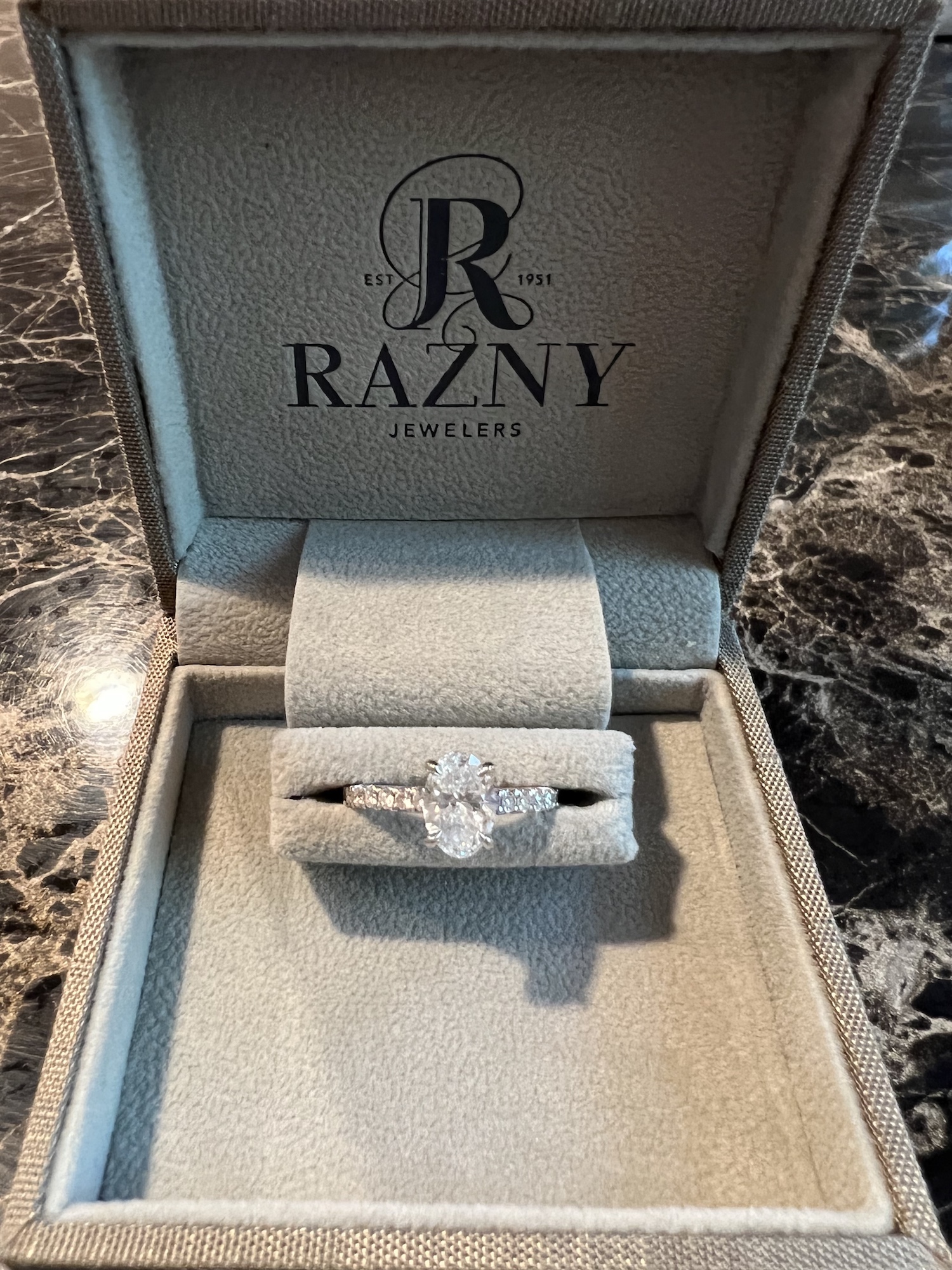 A box with a logo of a razny on it and a ring