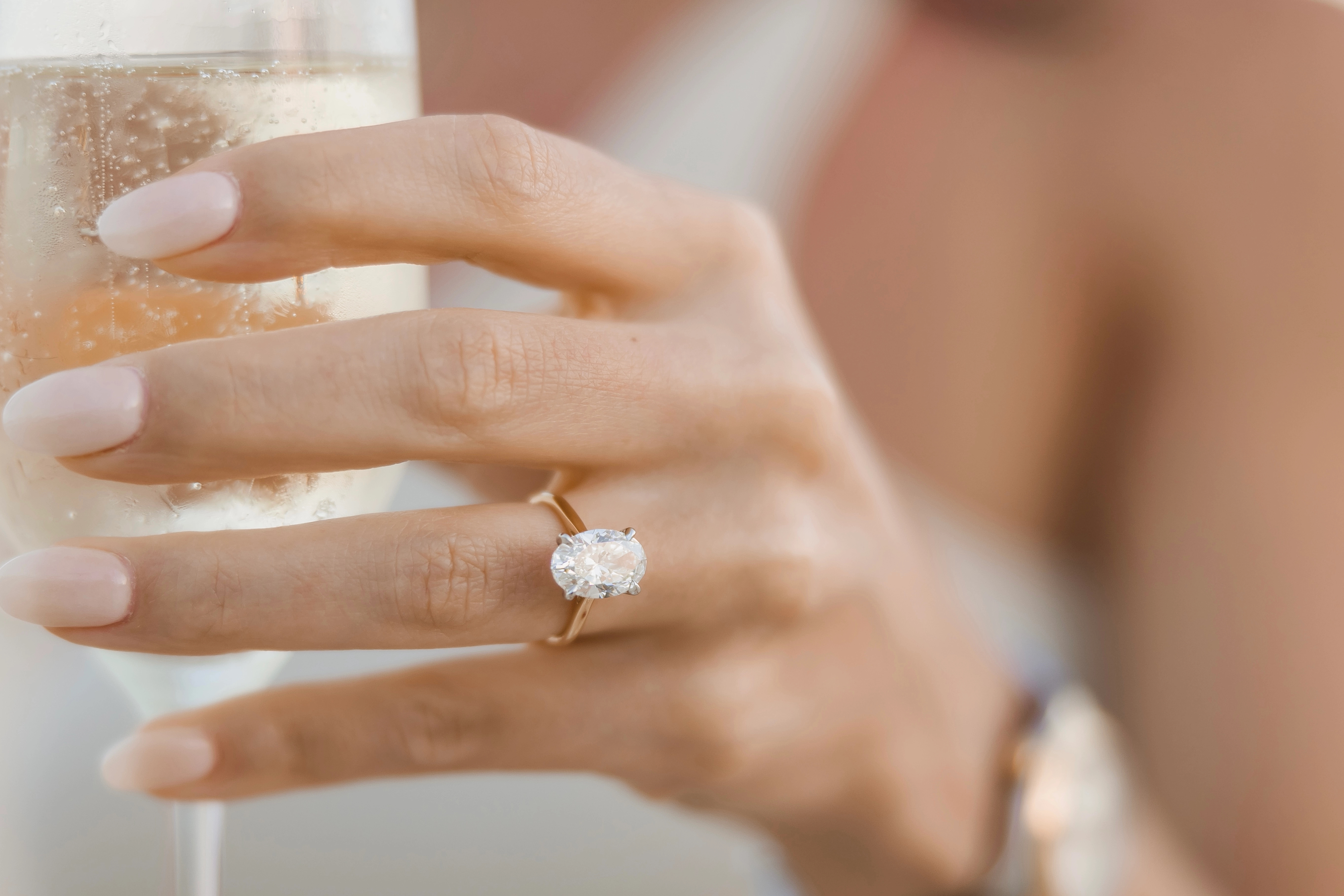 Dominique holding a glass and diamond ring on his hand.