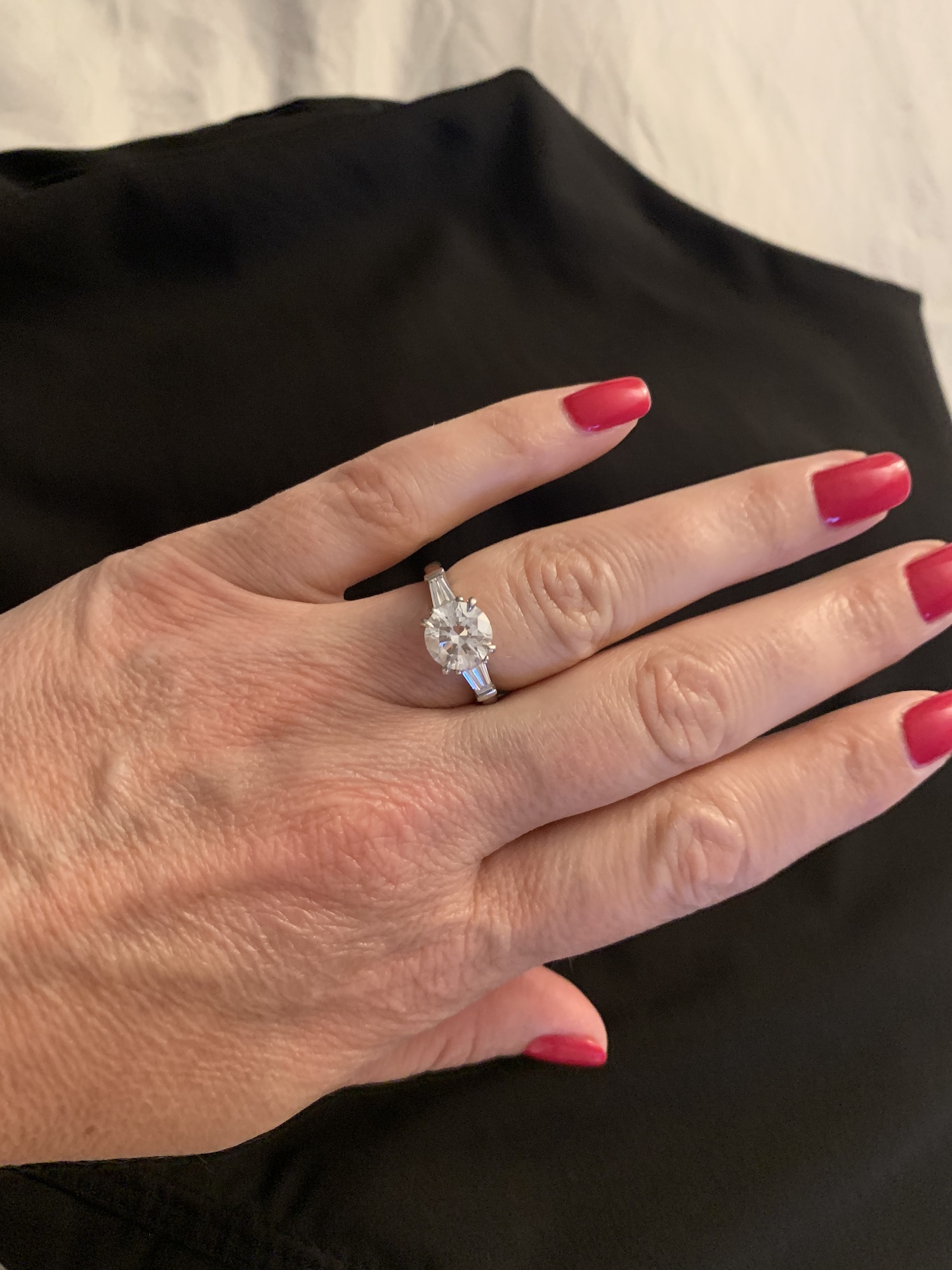 A lady hand with red nails and a ring on her finger