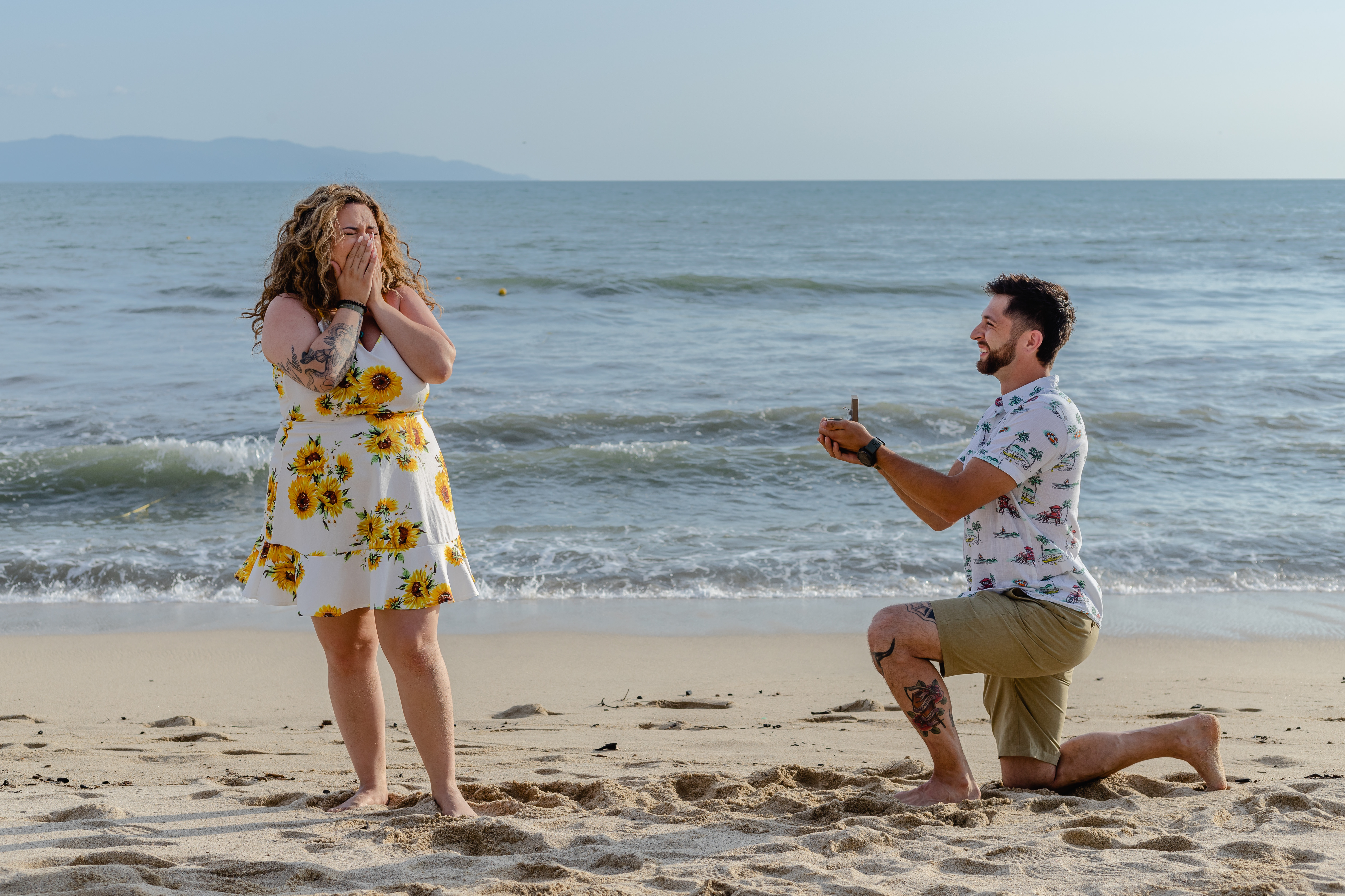 person perposing a girl on the beach and a girl cry with happiness