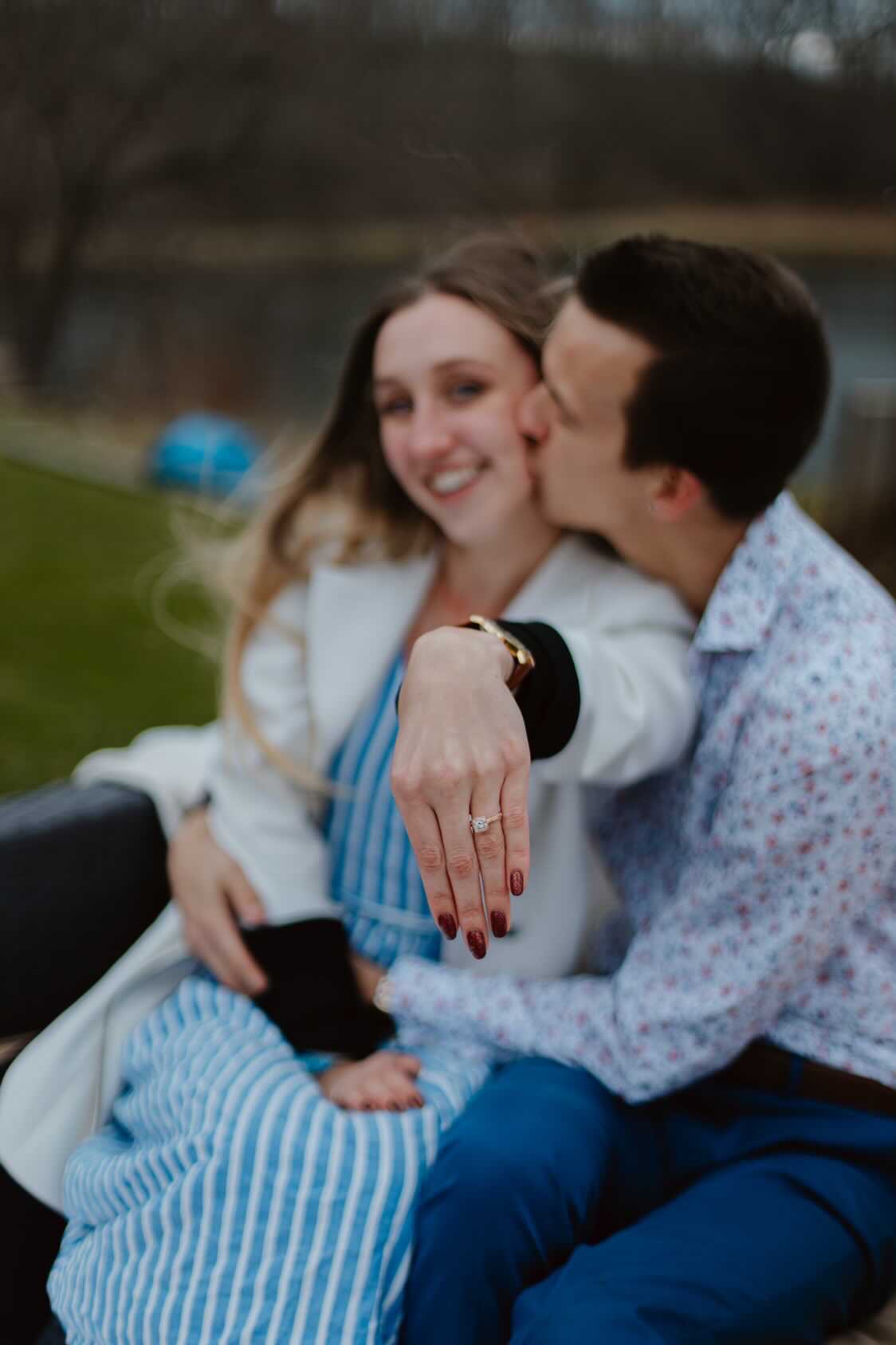 Lillie and Daniel sitting together to posing for a picture and Lillie showing his engagement ring.