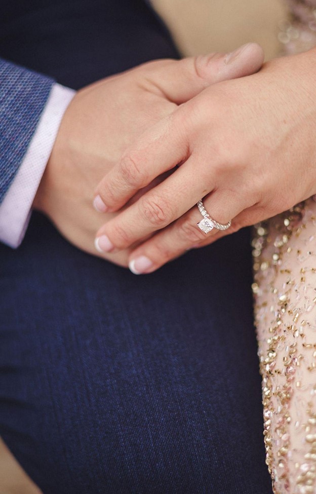 Natalie is holding Thomas hand and wearing a diamond ring on his hand