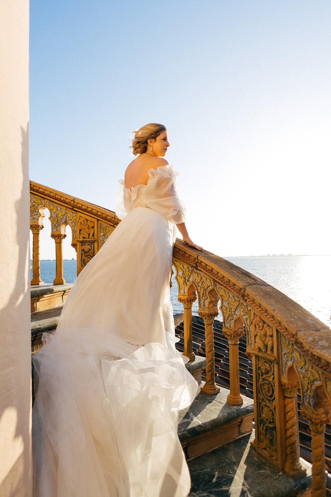 Sara wearing a wedding dress standing on staires for photoshoot